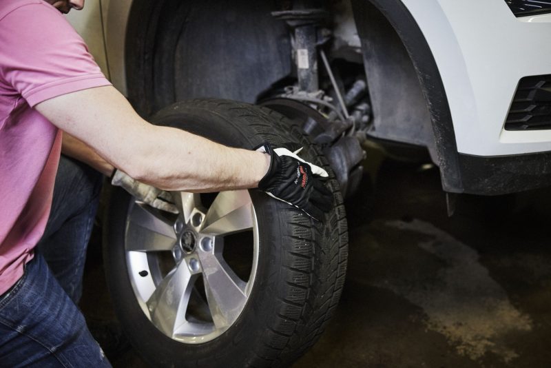 Asentaja vaihtaa auton renkaita